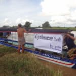 Phare Ponleu Selpak and iHerb preparing Cambodian fishing boat on river
