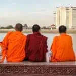 Three Cambodian monks sitting by the river in Phnom Penh