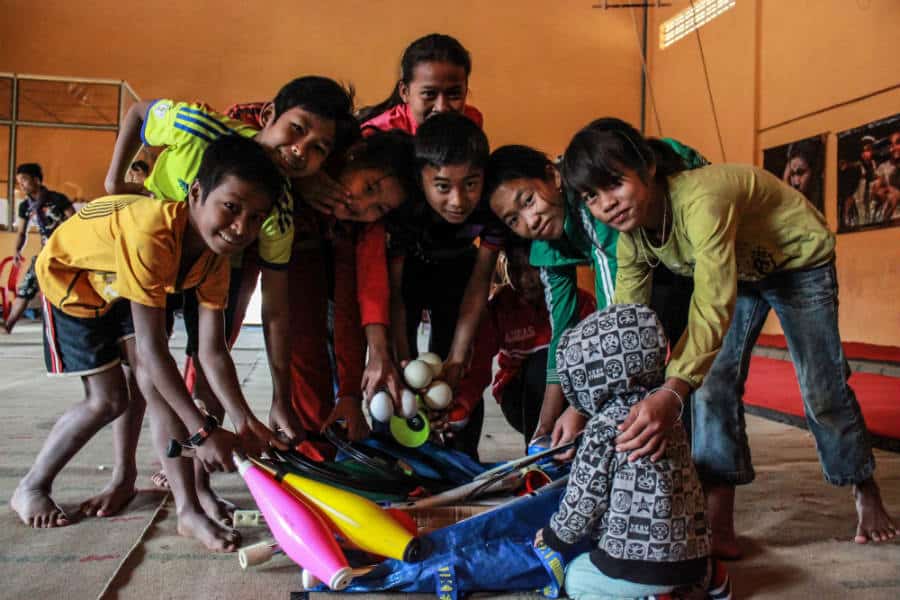 Mister Babache donates circus equipment to Phare Circus - students posing with juggling bowling pins, balls and rings