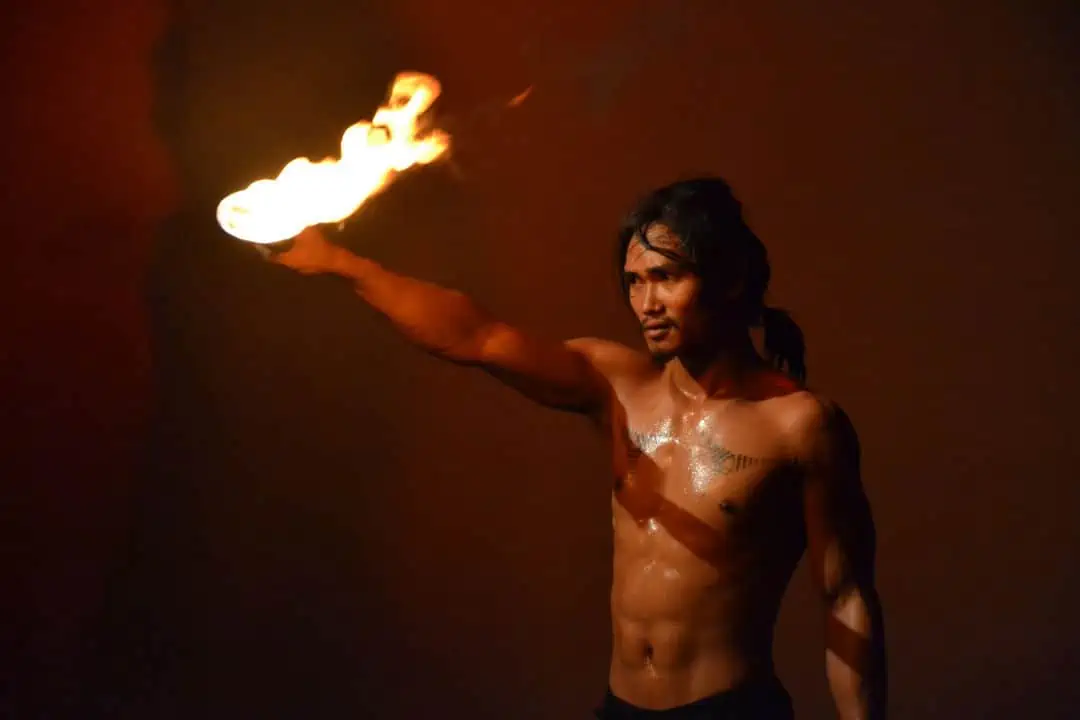 Phare Circus performer holding fire baton in the show "Eclipse"