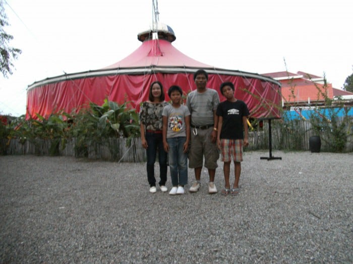 Family posing for photo in front of the Phare Circus big top