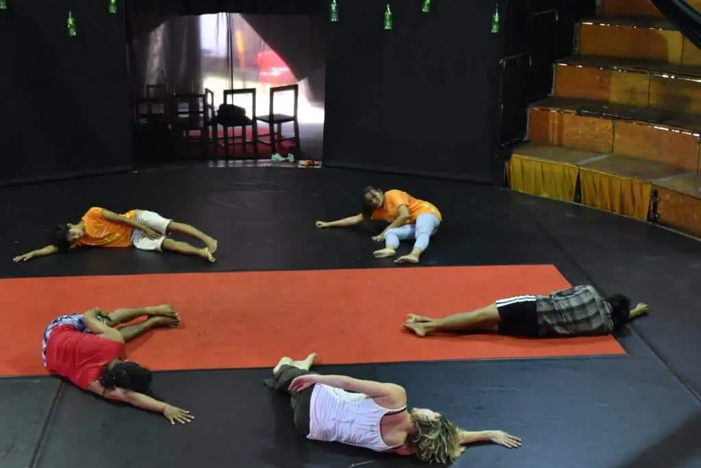 Phare Circus performers stretching on the big top stage during dance class