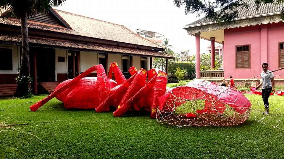 Giant Puppet Parade - large red ant on the grass