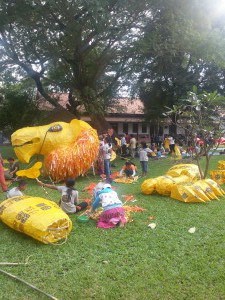 Pieces of a Giant Puppet Project yellow puppet laying on the ground ready to be assembled