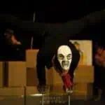 Phare Circus live show "Sokha" Cambodian symbolism - acrobat in black costume and skull mask on balance sticks