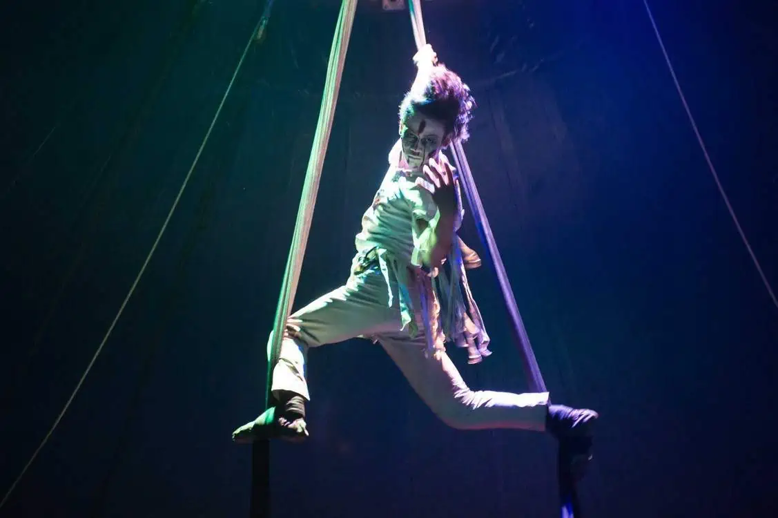 Phare Circus live show "Chills" - aerial silk performer in ghost costume and makeup suspended above the stage