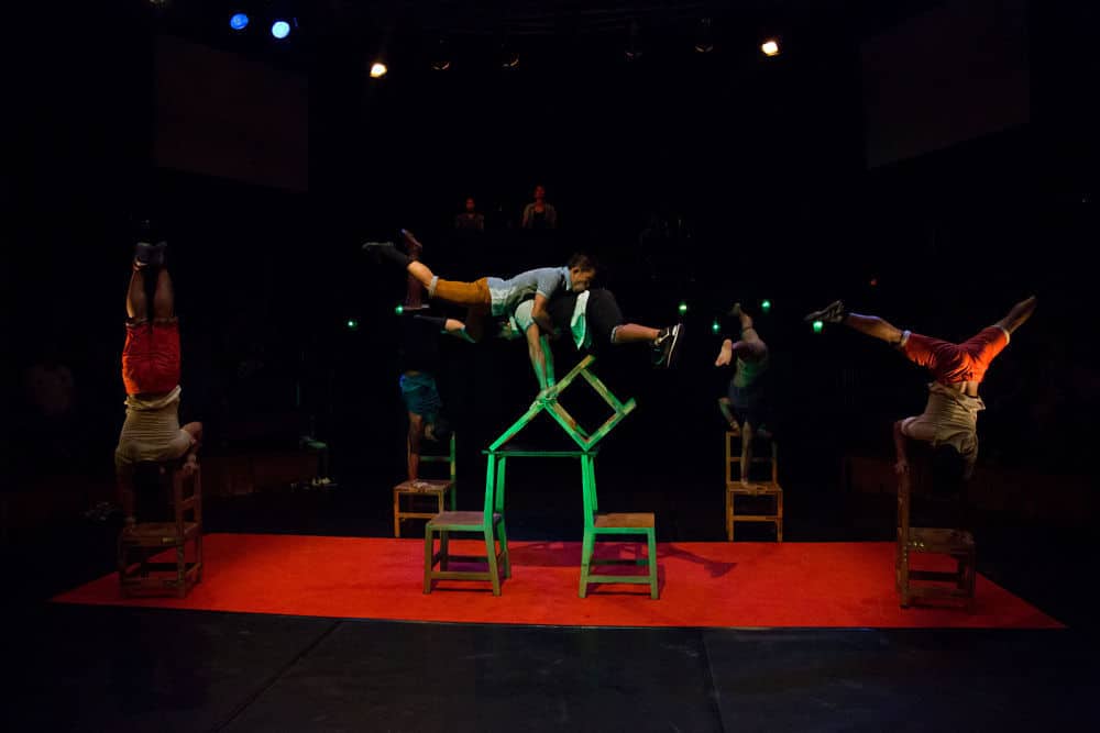 Phare Circus live performance "Chills" - performers balance on wood chairs around circular stage