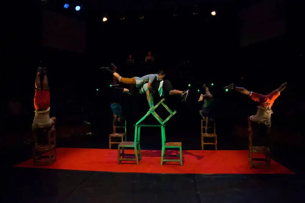 Phare Circus live performance "Chills" - performers balance on wood chairs around circular stage