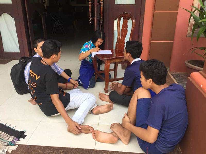 Cambodian students sitting on the floor having a discussion