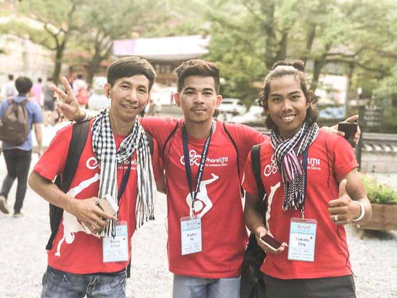 Phare Circus staff attending conference in Seoul, Korea, 3 men in red t-shirts and Cambodian traditional Krama