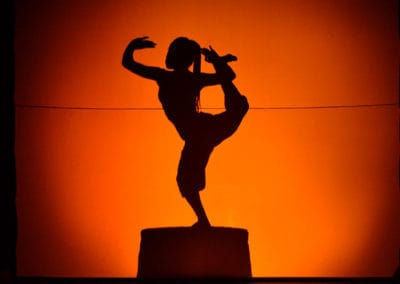 Phare Circus performance "Eclipse": female apsara dancer's shadow with orange lighting