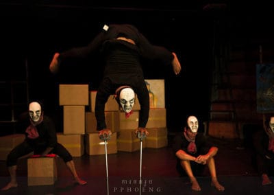 Phare Circus show "Sokha": artists in black costumes and skull masks, one performing on balancing sticks