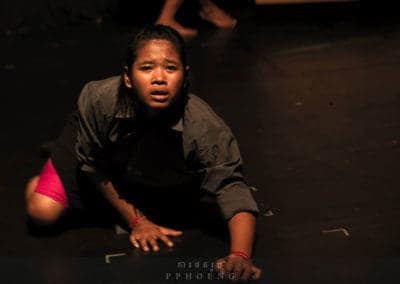 Phare Circus show "Sokha" - surviving Khmer Rouge: female performing artist on hands and knees with anguished expression