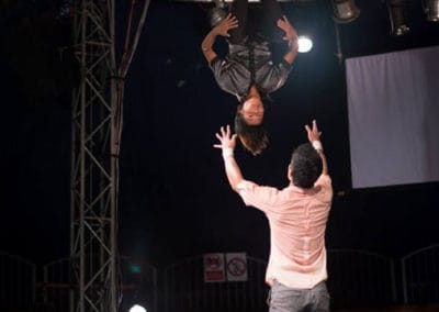 Phare Circus show "The Adventure": acrobat does back flip on to the sholder of a 2-man human tower.