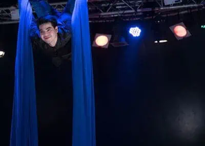 Phare Circus performance "Khmer Metal": smiling aerial silk artist inverted above bar stage