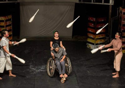 Phare Circus performance "Tchamlaek" artists juggling bowling pins in front of man in wheelchair