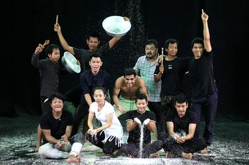 Phare Circus show "White Gold" artists and coach pose on stage covered with rice