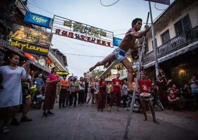 Phare Circus's Tini Tinou International Circus Festival (2016) - clown in diaper on ladder at Pub Street