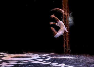 Phare Circus show - "White Gold" - man celebratory leap in the air over Buddhist mandala designed with Cambodian rice