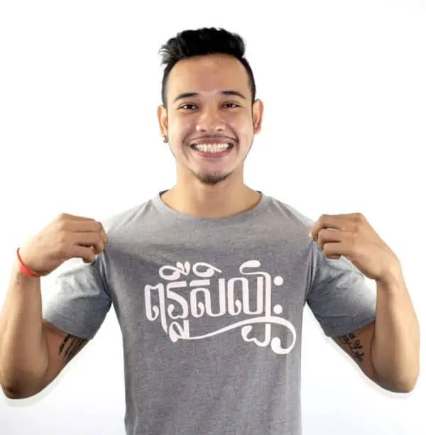 Phare Ponleu Selpak male artist wearing gray t-shirt with white writing Khmer text