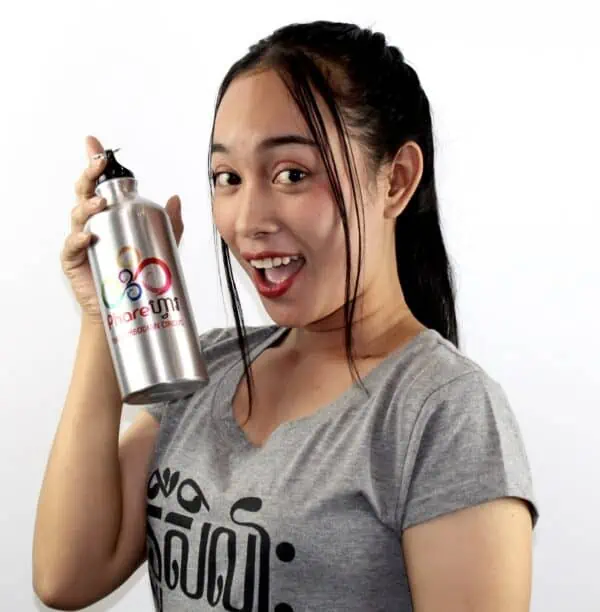 Phare Circus female artist wearing grey tshirt with black text art holding aluminum sports water bottle